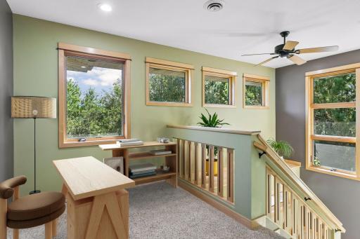 The loft on the upper level provides private space for an office/reading nook with wooded window views. Virtually staged.