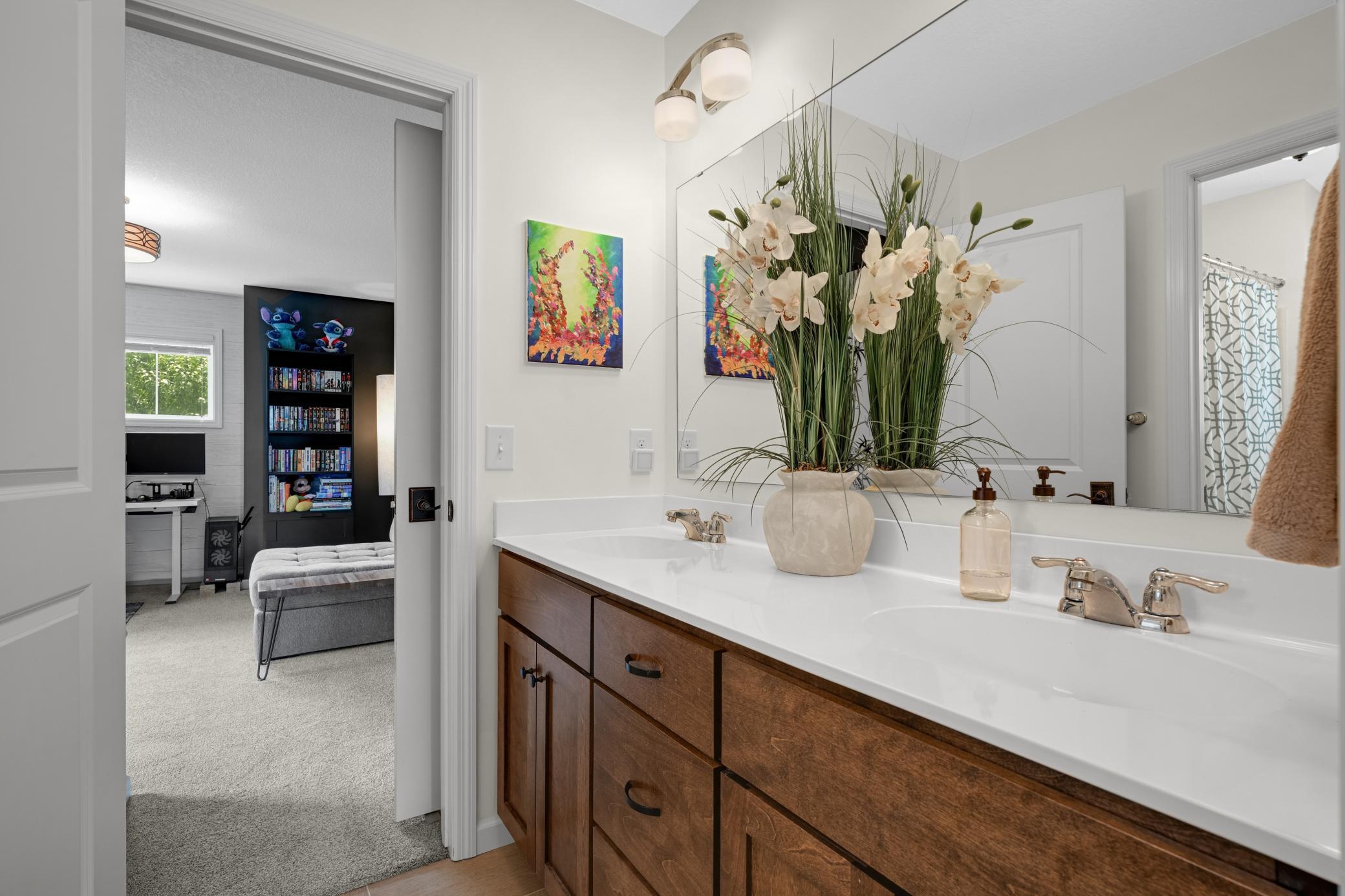 Jack and Jill bathroom featuring double sinks and a private water closet and shower makes getting ready a breeze.