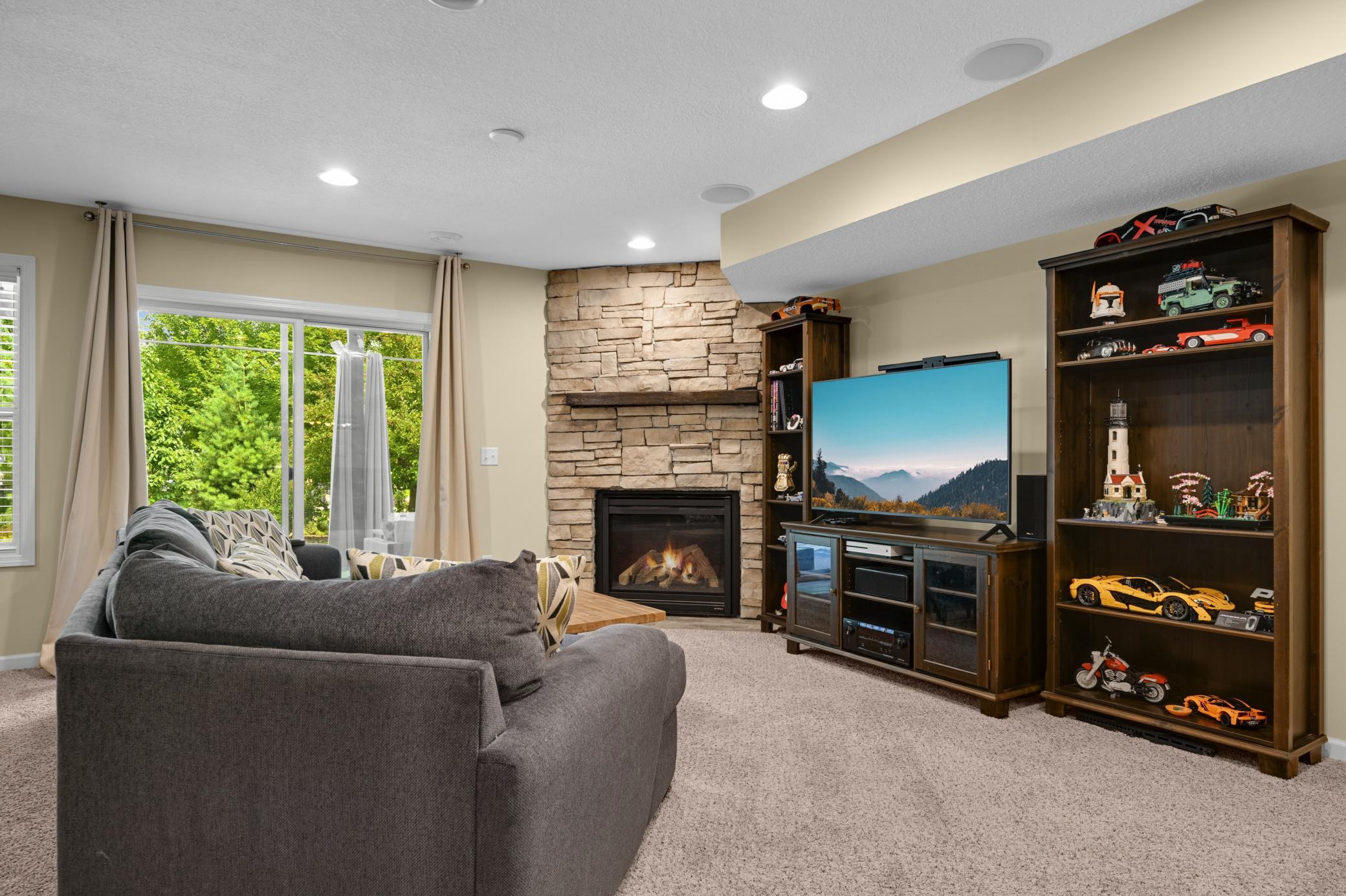 A second gas fireplace and stone accent wall anchor the ultimate place to hang.