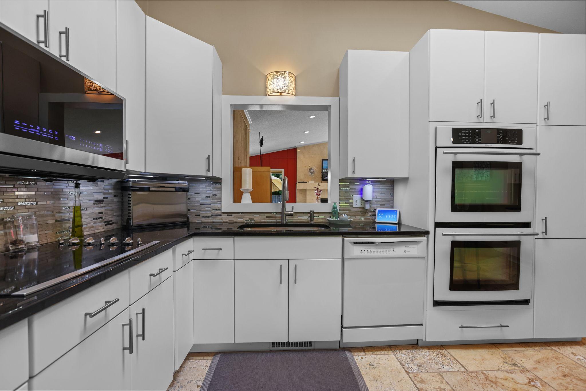 Custom granite countertops, luxury induction cooktop, separate wall ovens, tile backsplash, updated appliances