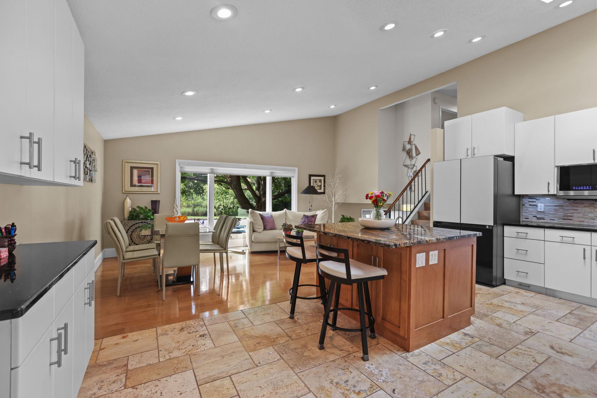 Large center island, tile kitchen floor, hardwood dining room floor, vaulted ceiling