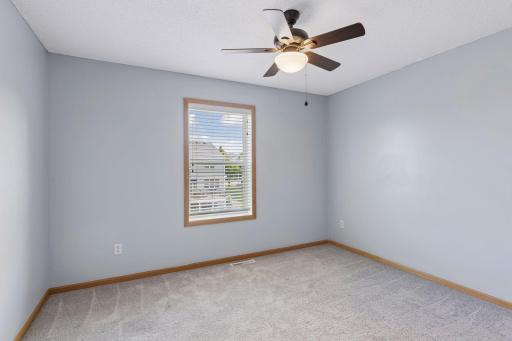 Additional upper level bedroom with ceiling fan.