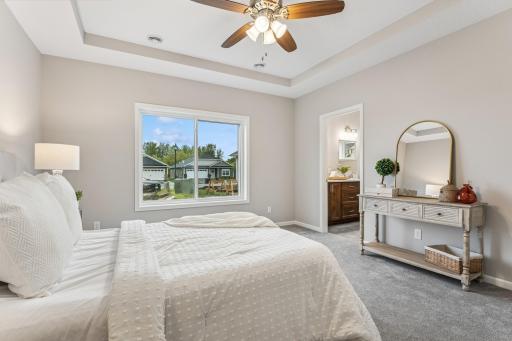 Lovely primary suite with walk-in closet and private bathroom with curbless shower. Photos from similar home.