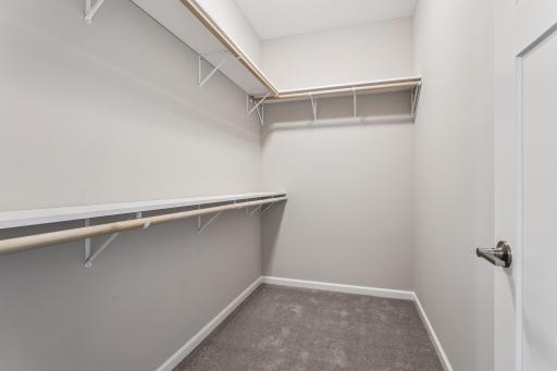 Lovely primary suite with walk-in closet and private bathroom with curbless shower. Photos from similar home.