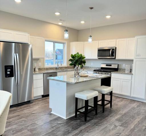 Open floor plan with great natural light, quartz countertops and stainless steel appliances. Photos from similar home.