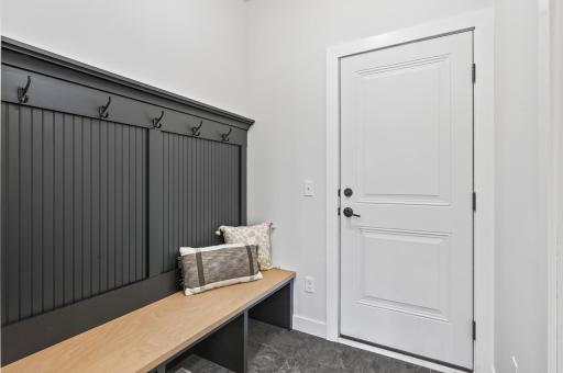 Mudroom with butler pantry and shelving units across.
