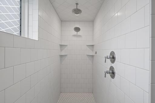 A true spa-like escape; the fully tiled shower with dual shower heads brings luxury and relaxation to this owner's bathroom.
