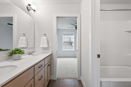 Well-designed Jack-and-Jill bathroom includes dual sinks and a separate private tub/toilet area, balancing shared space with personal privacy.