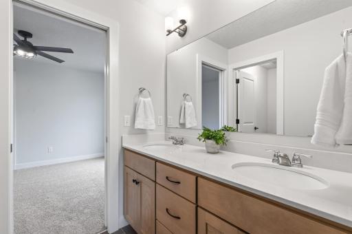 Well-designed Jack-and-Jill bathroom includes dual sinks and a separate private tub/toilet area, balancing shared space with personal privacy.