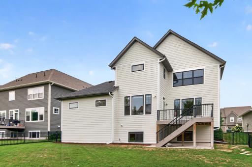 This stellar home boasts low-maintenance Hardi board siding, modern black window accents, and quality gutters, all visible from this striking backyard view.