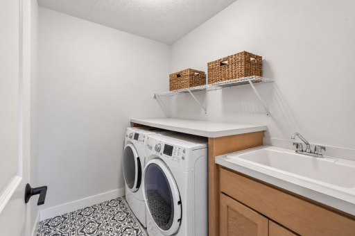 Say goodbye to hauling laundry up and down stairs; this upstairs laundry room is perfectly located and includes a handy laundry sink for extra convenience.