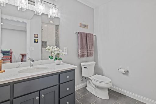 Stunning lower level 3/4 bathroom with abundant lighting and convenient for visiting guests or family.