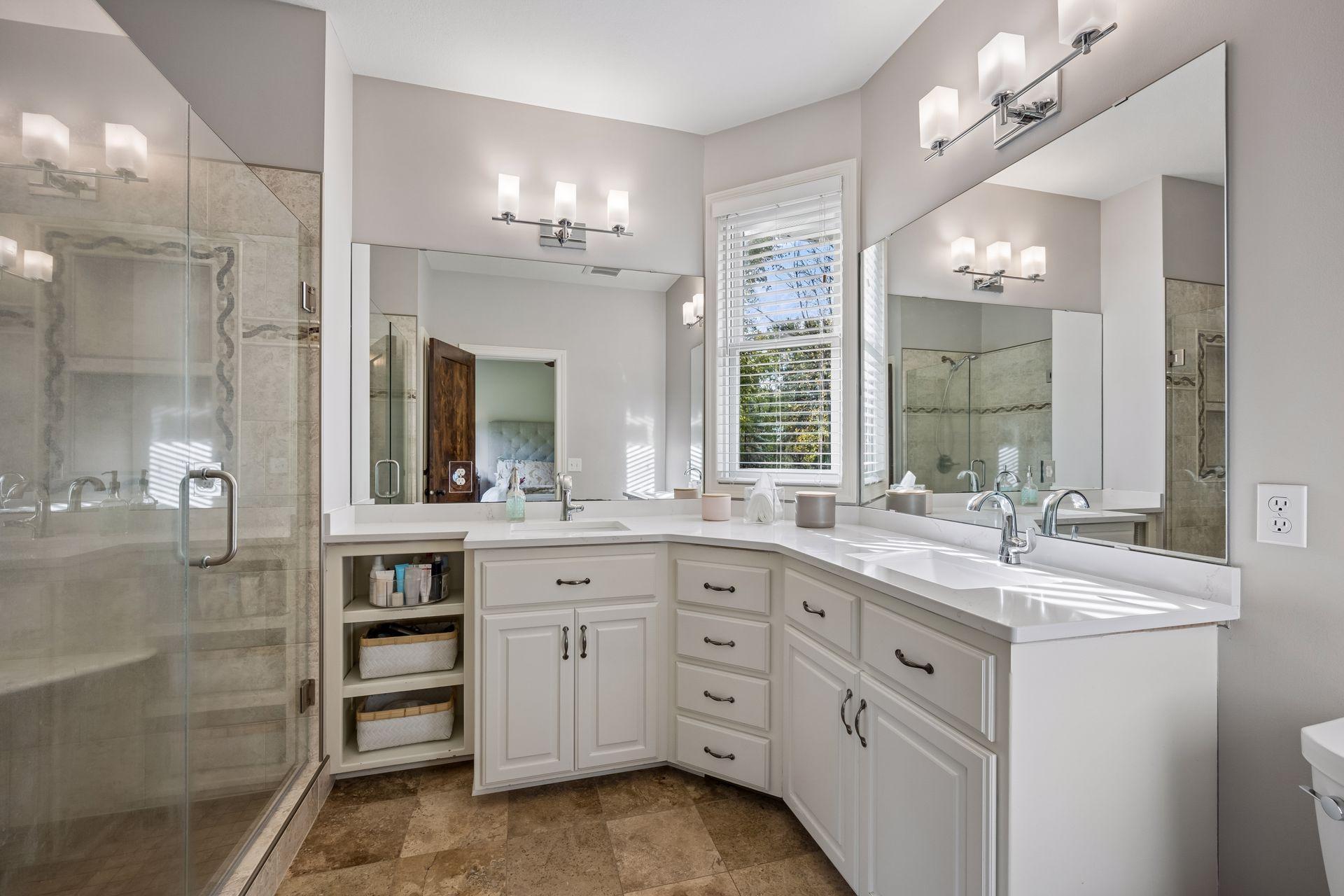 The private primary bath features dual sinks, generous vanity storage, and a tiled walk-in shower.