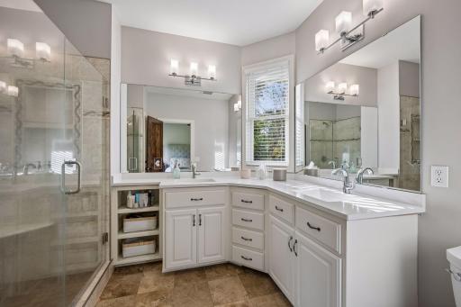 The private primary bath features dual sinks, generous vanity storage, and a tiled walk-in shower.