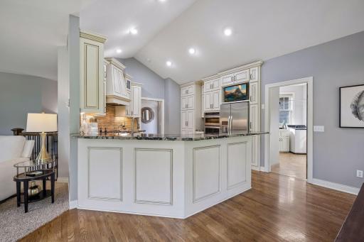 Maple soft-close cabinetry, granite countertops, and white oak flooring give the kitchen a timeless, polished look.