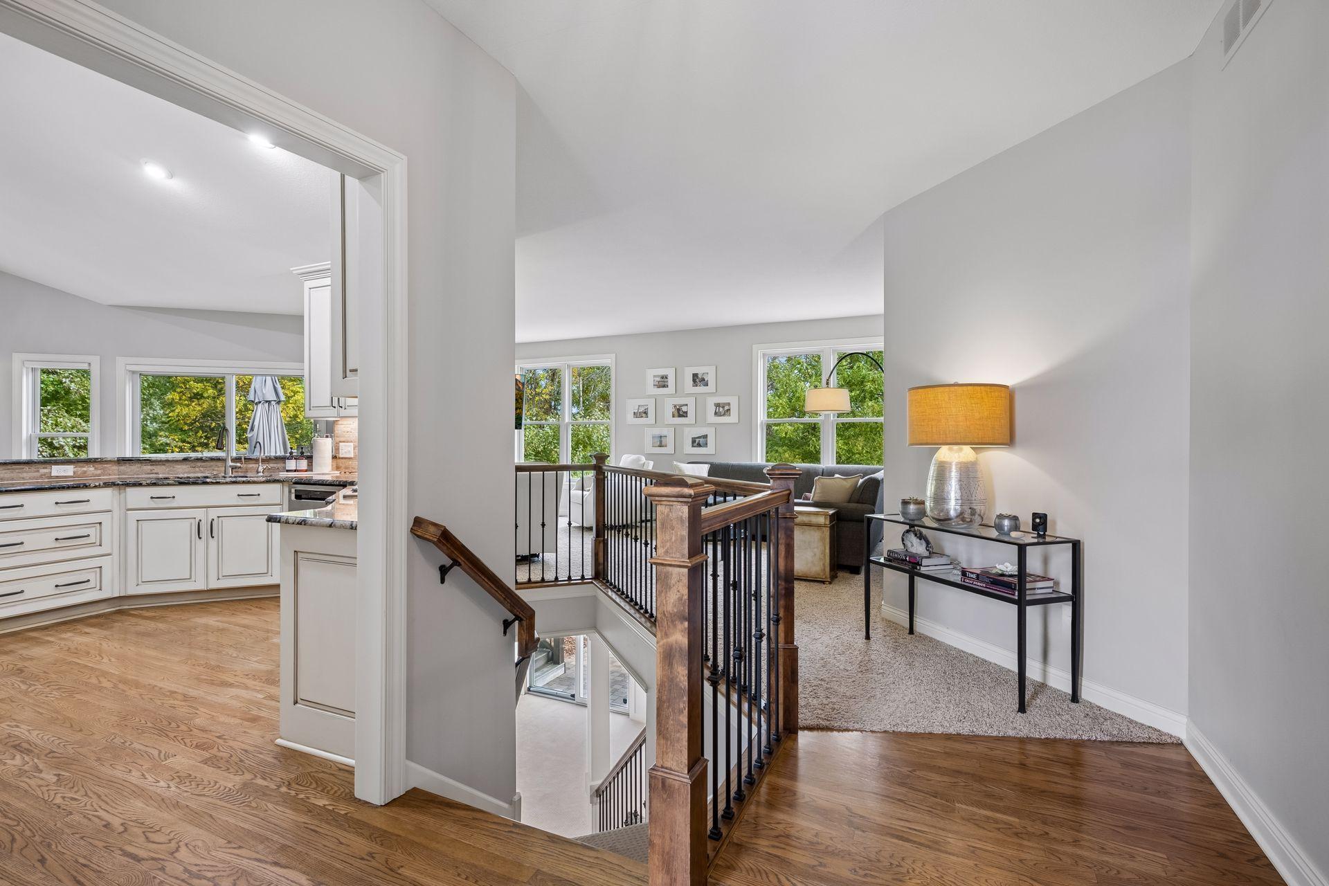 An open interior view highlights the natural flow between the kitchen, living room, and entry.