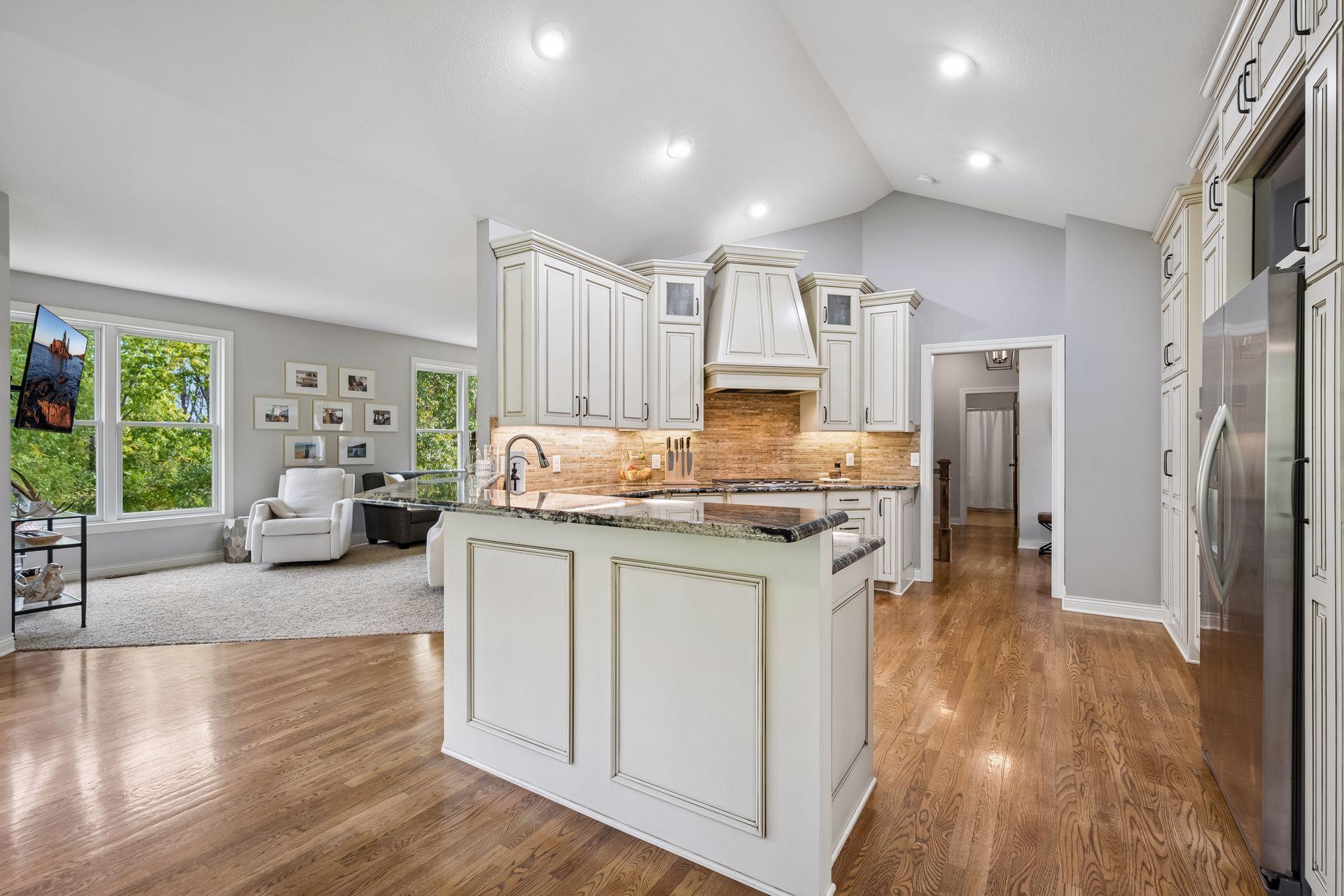 The breakfast bar complements the space and connects the kitchen to the informal dining area. The recessed lighting brightens the kitchen.