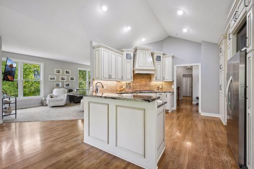 The breakfast bar complements the space and connects the kitchen to the informal dining area. The recessed lighting brightens the kitchen.