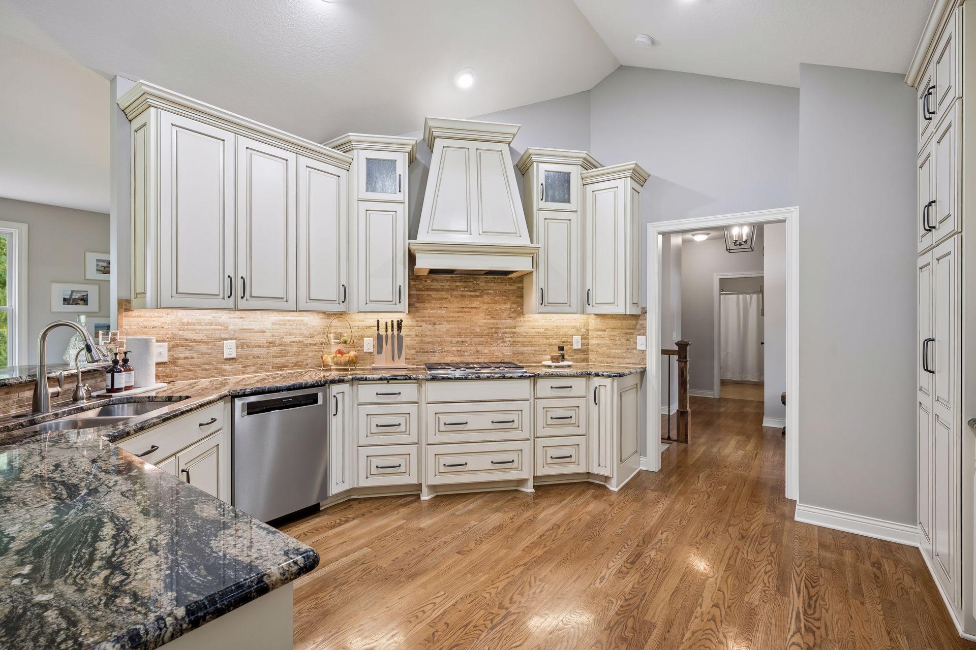 The well-appointed kitchen offers generous cabinetry, stainless-steel appliances, and a tiled backsplash.