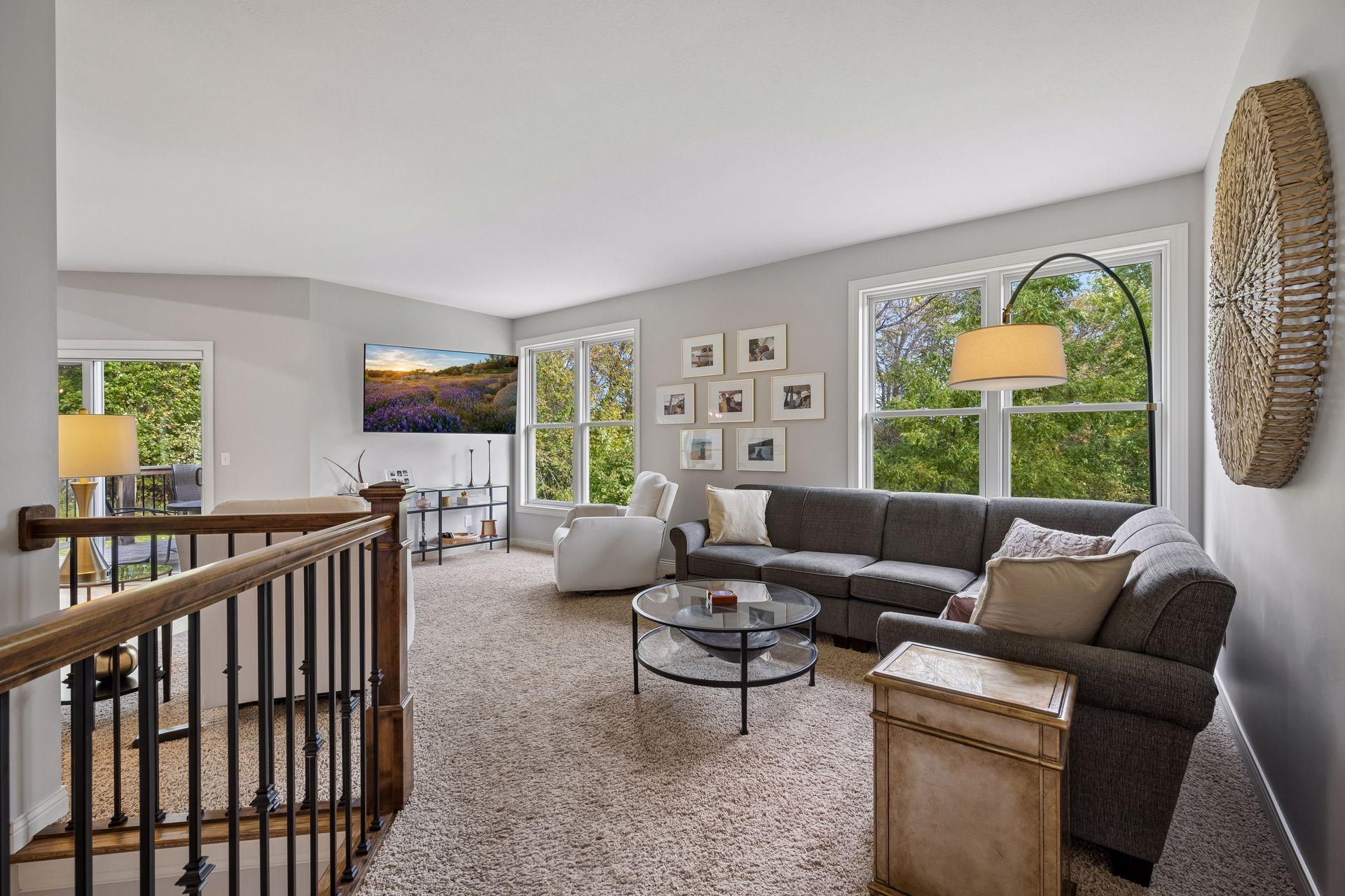 Large windows fill the living room with natural light while offering beautiful views of the surrounding trees.