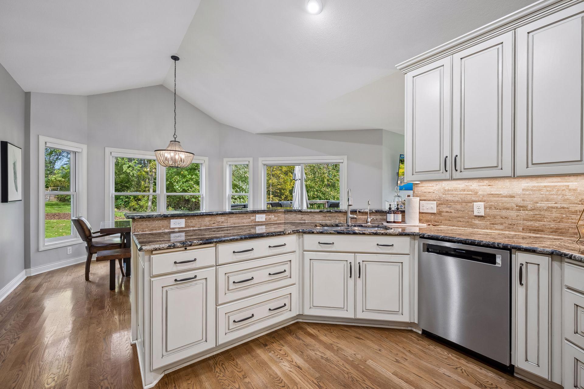 The kitchen combines granite countertops, stainless-steel appliances, and abundant maple cabinetry.