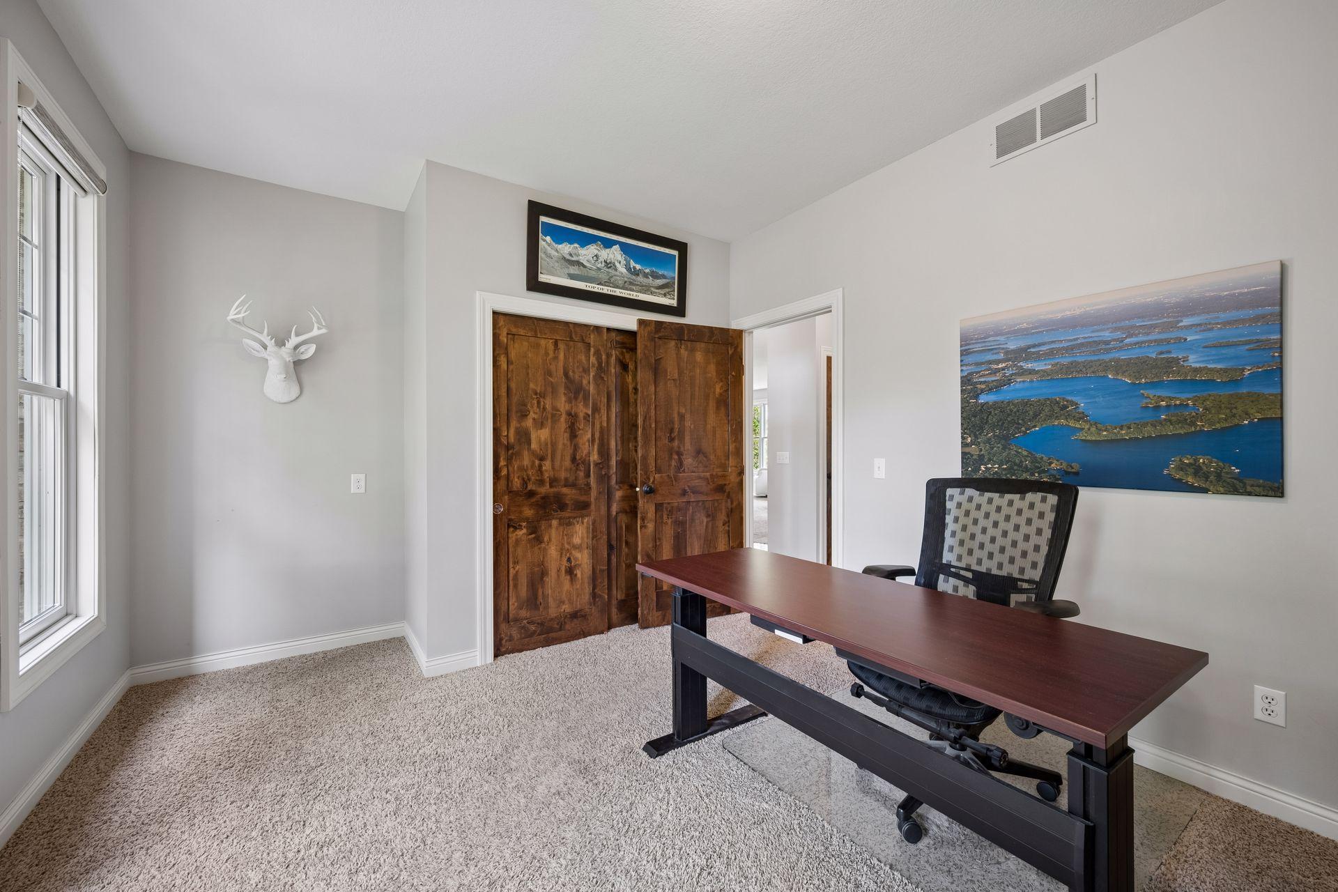 Another view of the main-level office highlights its two front-facing windows and knotty alder doors.