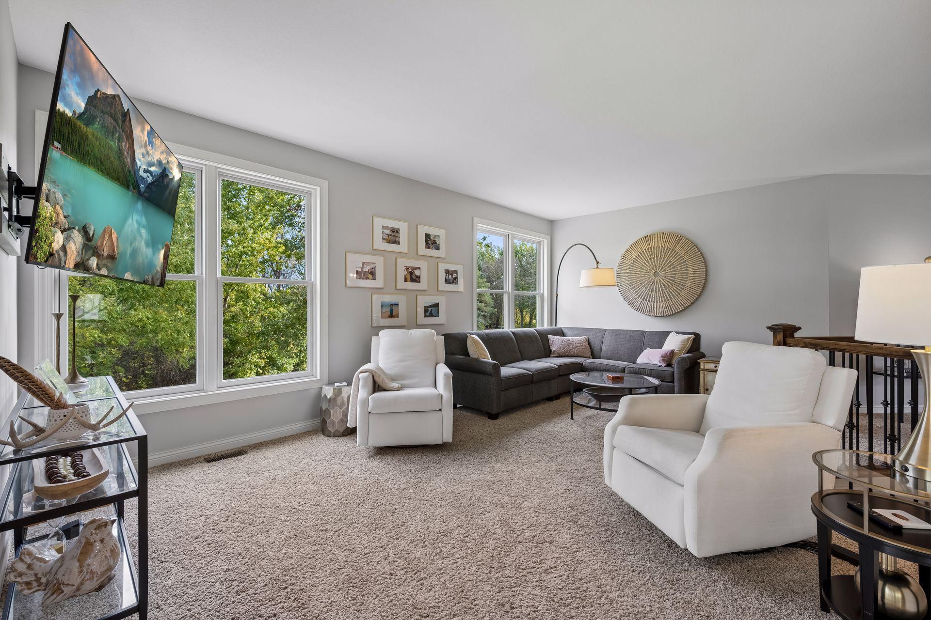 Multiple windows bring the outdoors in and enhance the living room’s bright, airy atmosphere.
