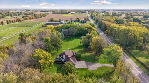 An aerial view showcases the homeâs private setting, generous yard, and large driveway.