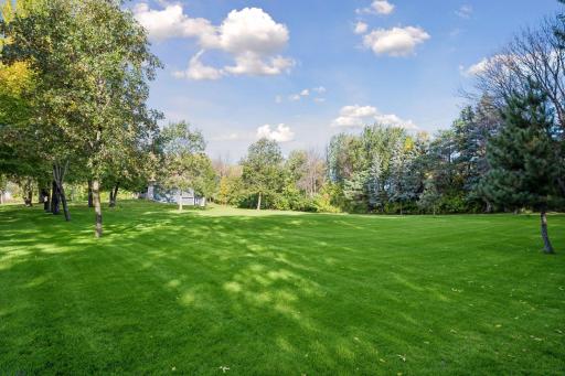 Mature trees are thoughtfully positioned throughout the yard, adding natural beauty and welcome shade.