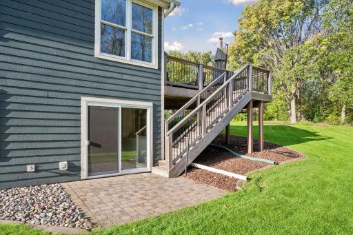 The deck stairs lead to a lower patio and the walkout entrance, creating multiple ways to enjoy the backyard.