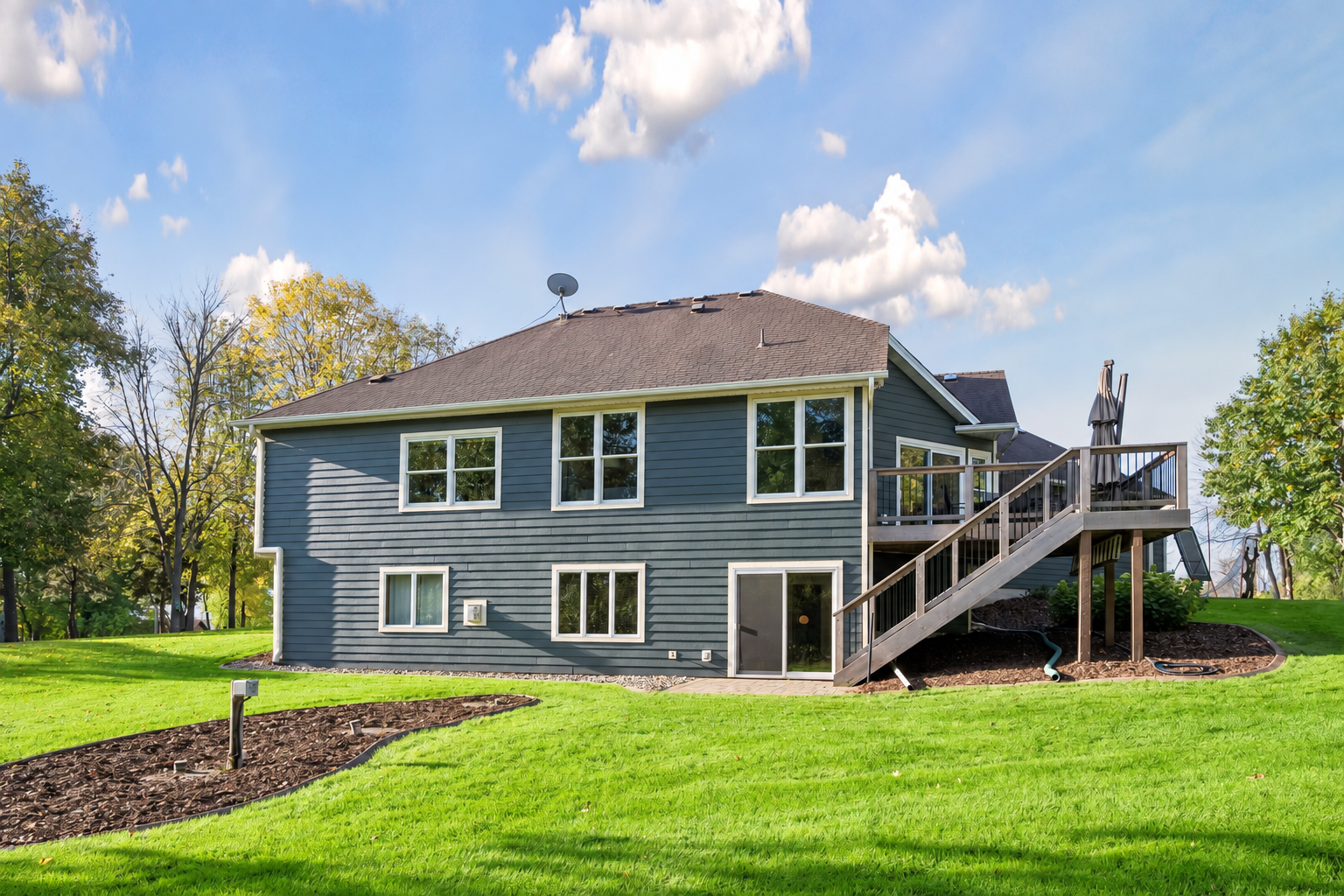 Stairs connect the deck to the backyard, while the lower-level patio offers another place to enjoy this amazing property. One of several mulched garden beds awaits your creativity.
