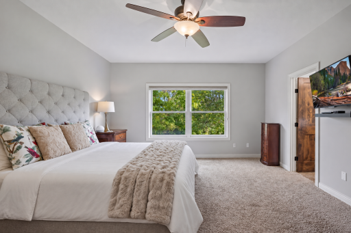 The main-level primary bedroom features neutral finishes and peaceful views.