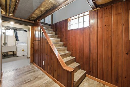 The lower-level staircase features warm wood paneling and rustic character, creating a distinctive transition between the home's living spaces.