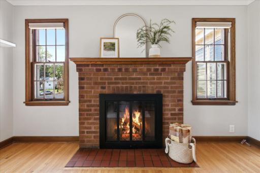 A classic brick fireplace serves as the focal point of the living room, creating a warm and inviting gathering space while showcasing the home's timeless character.