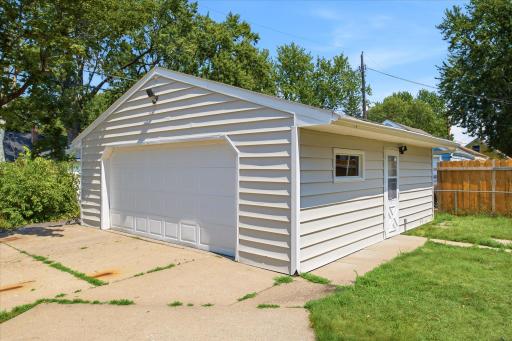 The detached garage offers generous parking and storage space, with a wide driveway, additional side entry, and a fully fenced area nearby.