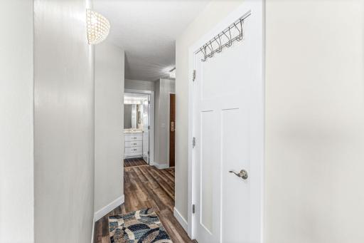 Welcoming condo entry featuring clean white finishes, practical wall hooks, and easy access to the main living spaces.