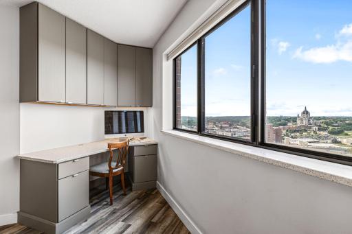 Built-in workstation beneath upper cabinetry creates a convenient home office with inspiring skyline views.