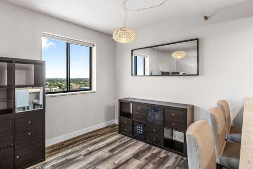 Flexible dining or workspace area positioned beside a large window with panoramic city views.