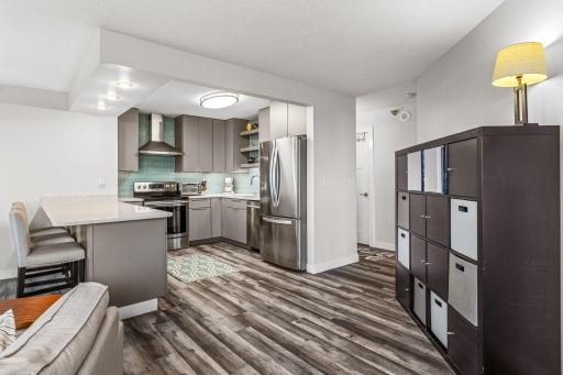 Open-concept living area featuring plank flooring, contemporary finishes, and a seamless connection to the kitchen.