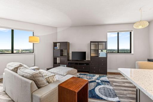 Bright living area framed by two large windows with elevated views across downtown St. Paul.