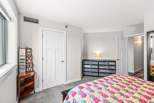 Bedroom view highlighting flexible furniture placement, natural light, and large walk in closet access.