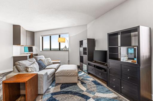 Open living room featuring expansive corner views, versatile furniture placement, and contemporary plank flooring.