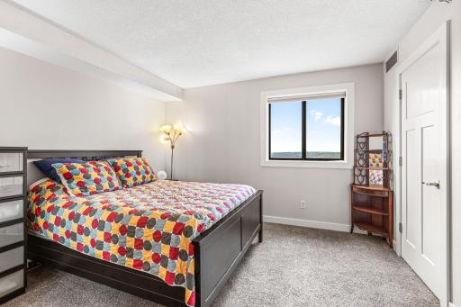 Primary bedroom featuring neutral carpeting, generous proportions, and a window providing natural light