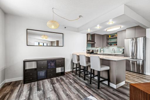Dining area with seating at the kitchen peninsula, modern lighting, and an easy flow into the living space.