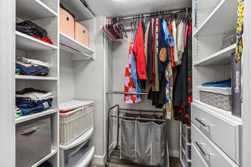 Large walk-in closet in primary room with extensive shelving and hanging space for organized wardrobe storage.