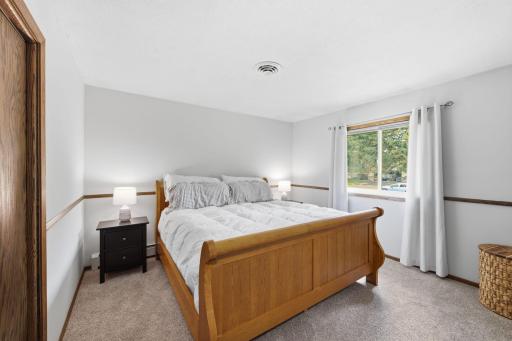 Spacious bedroom with large window, natural light and generous floor space.