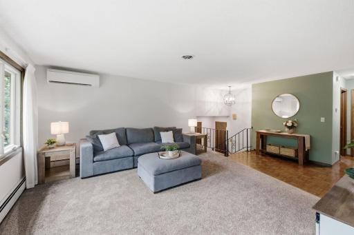 Generous main-level living space with multiple windows bringing in natural light from the wooded surroundings.