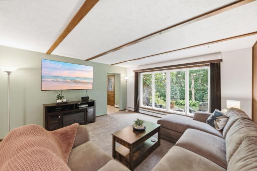 Spacious family room with large windows, exposed ceiling beams and direct access to the backyard patio.