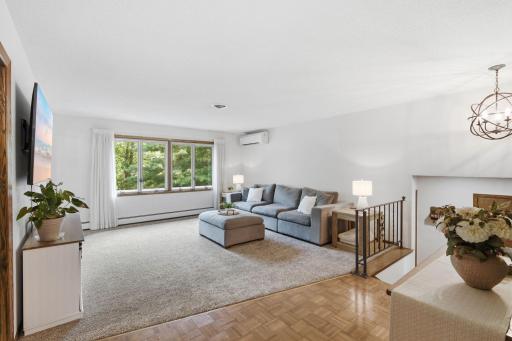 Spacious living room with oversized windows, abundant natural light and an open connection to the dining area.