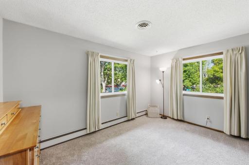 Bright bedroom featuring windows on two walls and abundant natural light.